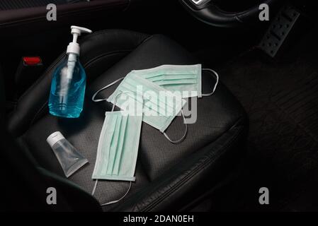 Ethyl Alcohol hand gel and surgical face mask placed on the car seat in a car, concept for coronavirus, covid19 Stock Photo