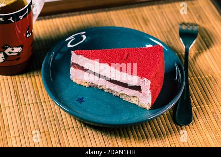 Raspberry holiday cheesecake Servings on a table with bamboo napkin Stock Photo