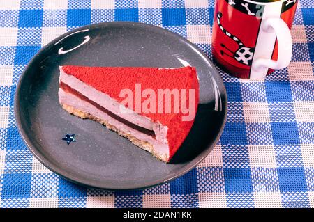 Raspberry holiday cheesecake Servings on a table with white blue  checkered tablecloth Stock Photo