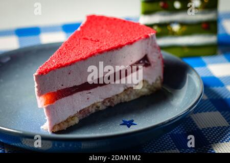Raspberry holiday cheesecake Servings on a table with white blue  checkered tablecloth Stock Photo