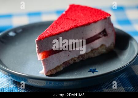 Raspberry holiday cheesecake Servings on a table with white blue  checkered tablecloth Stock Photo
