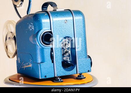 Old 8mm Film Projector over light textured background. Retro style 60's banner concept Stock Photo