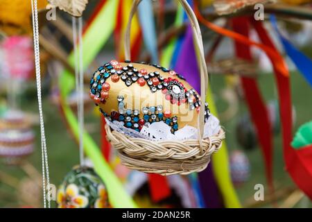 Folk art and festival of Easter Eggs. Easter holiday. Multicolored Easter eggs hanging on artificial trees Stock Photo