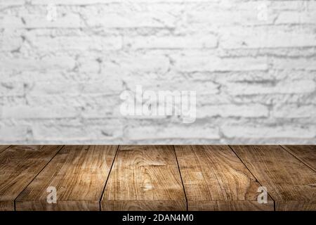 White old brick wall with wooden table foreground for product montage advertising background. Stock Photo