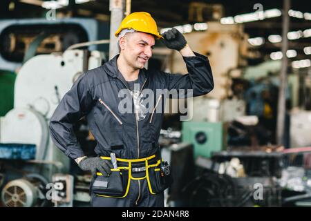 smart handsome European Russian worker happy working in factory with yellow helmet and safety suit portrait standing at heavy industry workplace. Stock Photo