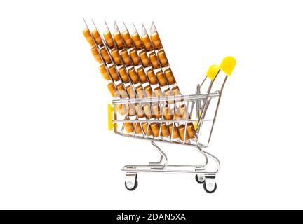 Group of vitamin c blister packages in a small shopping cart isolated on white. Side view, copy space. Autumn immunity boost concept. Stock Photo