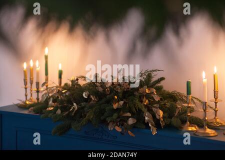 Christmas decoration with burning candles and christmas tree branches. Vintage style toned picture Stock Photo