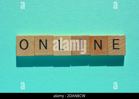 Online, word in wooden alphabet letters isolated on turquoise background Stock Photo