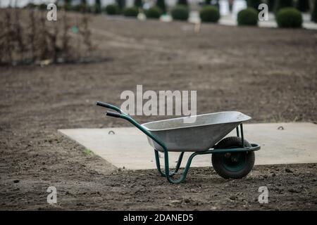 Empty wheelbarrow on the site of a tree plantation. Stock Photo