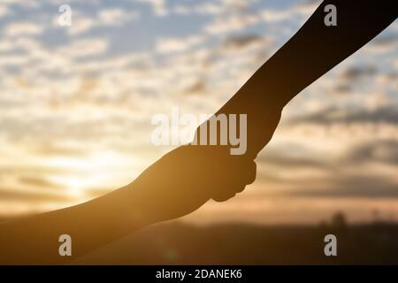 Silhouette of giving a helping hand, hope and support each other over ...