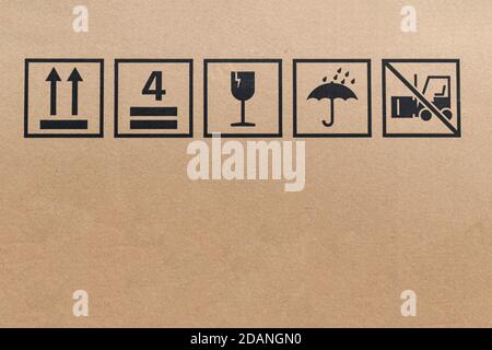 Black fragile sign icons on cardboard. Package box with symbol indicating fragile item, Need careful handling. Stock Photo