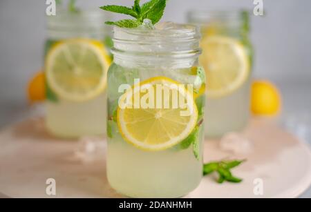 three Lemon mojito cocktail with mint in mason jars on top of wood. Stock Photo