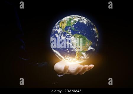 Environment concept. Earth in human hands on black background. Elements of this image furnished by NASA Stock Photo