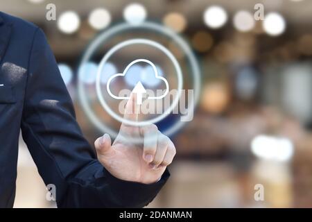 Businessman hand pressing cloud upload icon on virtual touchscreen interface. copy space. Stock Photo