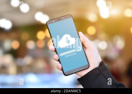 Businessman hand using mobile phone with cloud download form stored data. Stock Photo