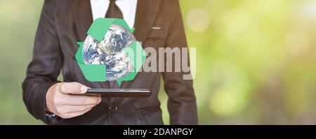 Businessman hand holding mobile phone with Earth and logo recycle icon. Concept of save environmental. Stock Photo