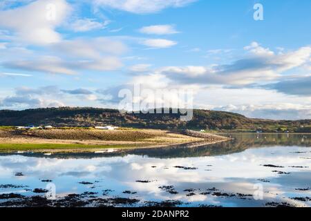 Tranquil scene with clouds reflected in calm sea at high tide in Red Wharf Bay, Isle of Anglesey, Wales, UK, Britain Stock Photo