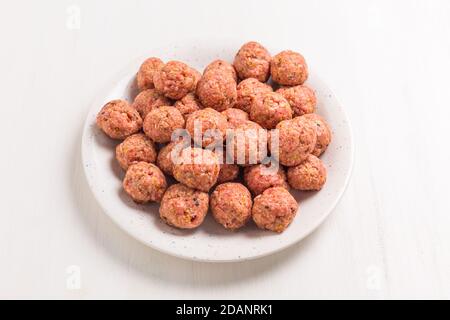 Raw meatballs on plate, ready for cooking or baking on white background Stock Photo
