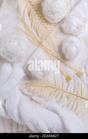 Knitting concept with needles, wool, sweater and yarn in white color Stock Photo