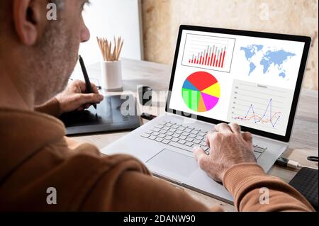 businessman analyzing statistics on laptop screen, working with financial graphs charts online, using business software for data analysis and project Stock Photo