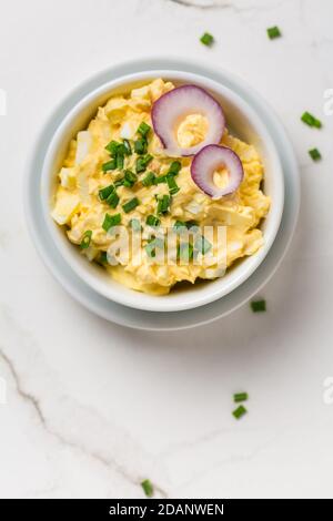 Egg spread with onion and chives on marble background Stock Photo
