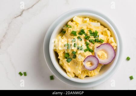 Egg spread with onion and chives on marble background Stock Photo
