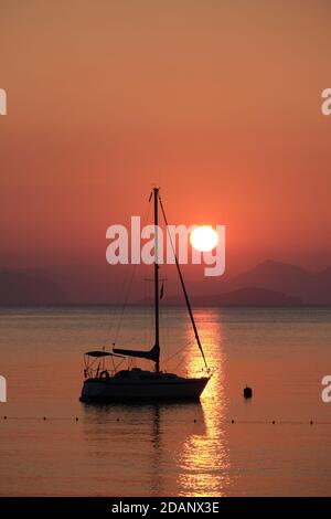 Silhouette of a boat and mountains at sunrise, Turunc, Turkey Stock Photo