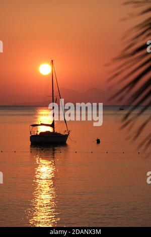 Yacht silhouette in Aegean sea over sun and mountains, Turkey Stock Photo