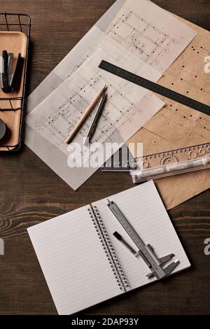 View of stapler in basket, pen with pencil and rulers on blueprints and calipers Stock Photo