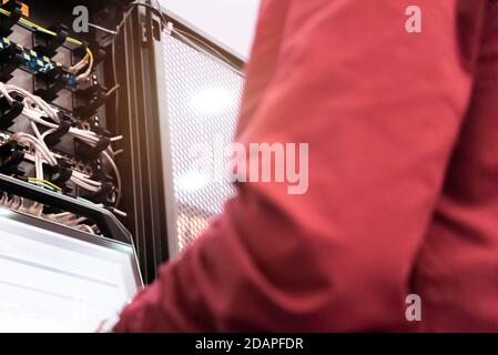 Young it engeneer business man with thin modern aluminium laptop in network server room. Young it engeneer in datacenter server room Stock Photo