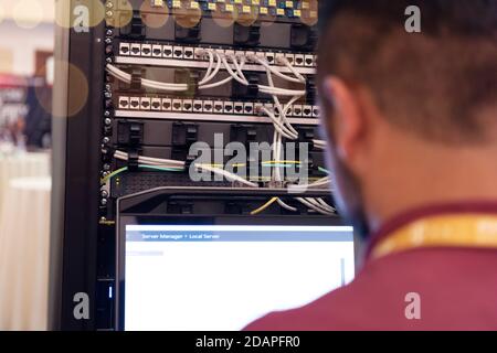 Young it engeneer business man with thin modern aluminium laptop in network server room. Young it engeneer in datacenter server room Stock Photo