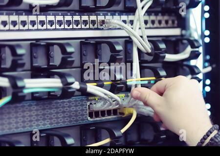 Young it engeneer business man with thin modern aluminium laptop in network server room. Young it engeneer in datacenter server room Stock Photo