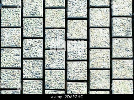 small cobblestone sidewalk made of cubic stones - tileable texture, gray on the sidewalk Stock Photo