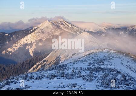 Beautiful landscape on the cold winter day. High mountain with snow white peaks. Snowy background.