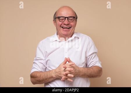 Senior hispanic man in glasses laughing on joke. Stock Photo