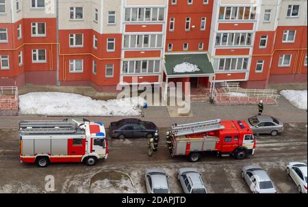 Fire engine in the courtyard of a multi-storey residential building in winter. Stock Photo