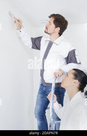 couple painting their new home holding a paint roller Stock Photo