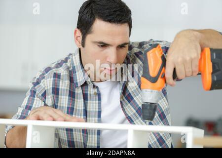 a man drilling wood plank Stock Photo