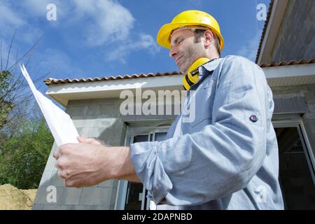 construction worker wearing protective hard hat and ear defenders Stock Photo