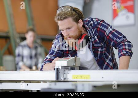 young attractive man doing woodwork in carpentry Stock Photo