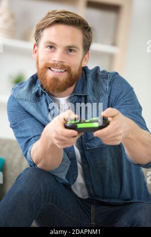 attractive young man using joystick or joypad for videogames Stock Photo