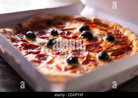 Pizza in a cardboard box on table ready to customer. Stock Photo