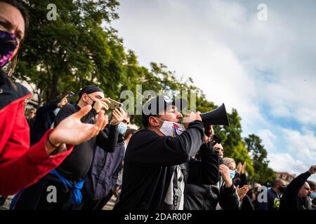 A protester wearing a face mask speaks on a megaphone.Restaurant, bar, nightclub and catering owners protest in the Prace do Rossio, Lisbon, against the government measures and ask for financial support, due to the economic crisis caused by the COVID-19 pandemic in Portugal. Stock Photo