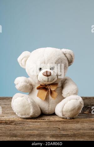 White or light brown adorable teddy bear with christmas decorations and gifts. Holiday concept with toy plush bear and christmass gifts on the wood Stock Photo