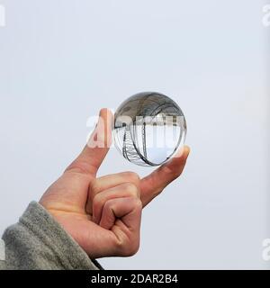 Hand holding glass ball, Old Harburg Elbe bridge is reflected in it, Harburg, Hamburg, Germany Stock Photo