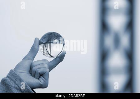 Hand holding glass ball, Old Harburg Elbe bridge is reflected in it, Harburg, Hamburg, Germany Stock Photo