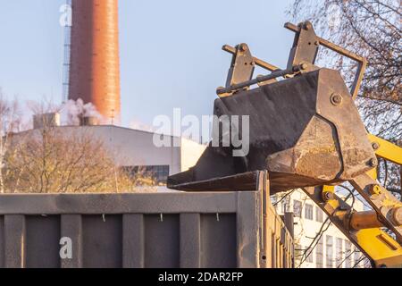 loader bucket loads into the back of the truck Stock Photo