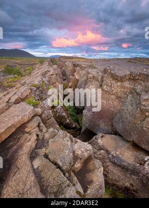 Red column in the plain with dramatic clouds in the evening sky in the fault zone, Grjotagja, Skutustaoir, Norourland eystra, Iceland Stock Photo