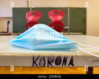 Empty classroom, seated, face mask and lettering KORONA on table, single tables without distance rule, Corona crisis, Germany Stock Photo