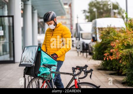 Food delivery service, rider delivering food to clints with bicycle - Concepts about transportation, food delivery and technology Stock Photo